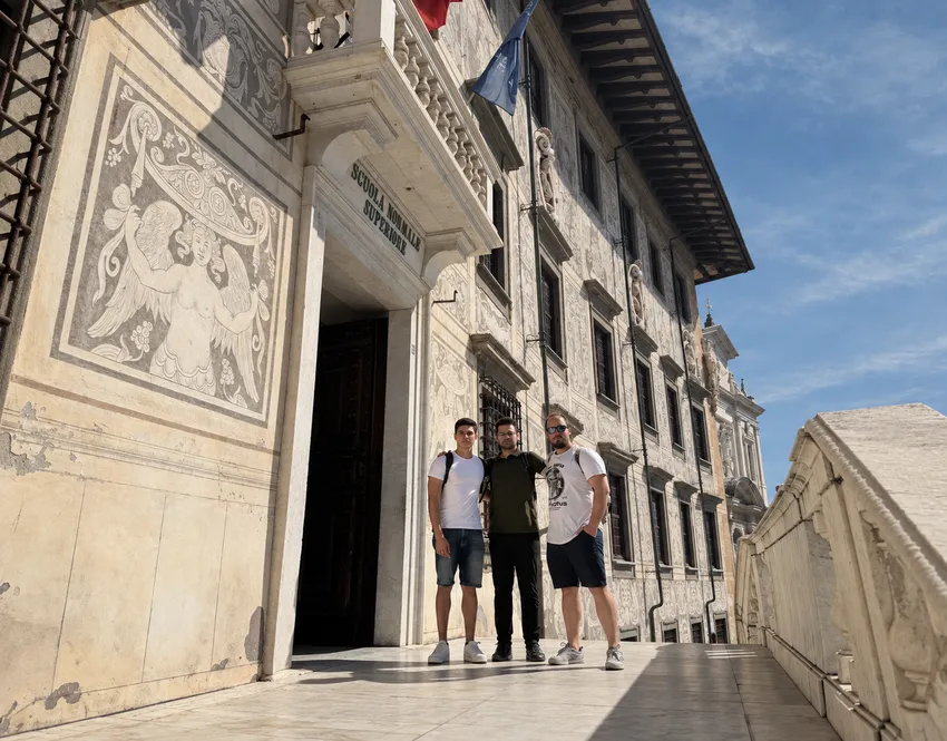 Three visitors standing at the entrance to the Scuola Normale Superiore